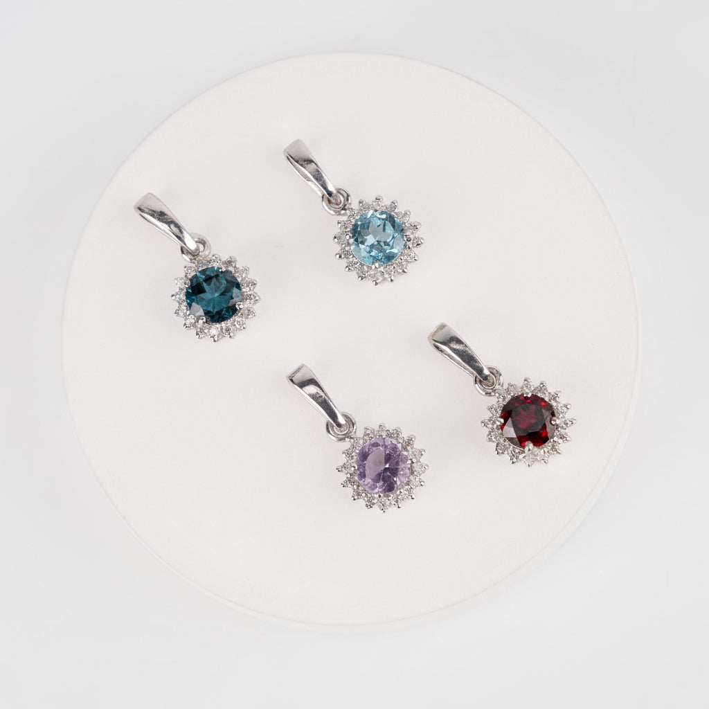 Set of four gemstone pendants on a white background