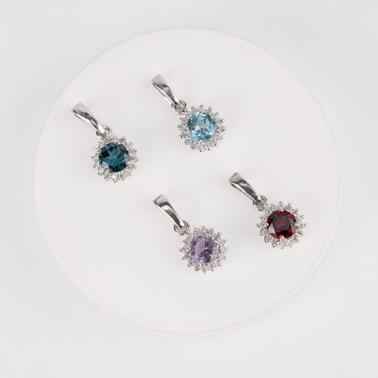 Set of four gemstone pendants on a white background