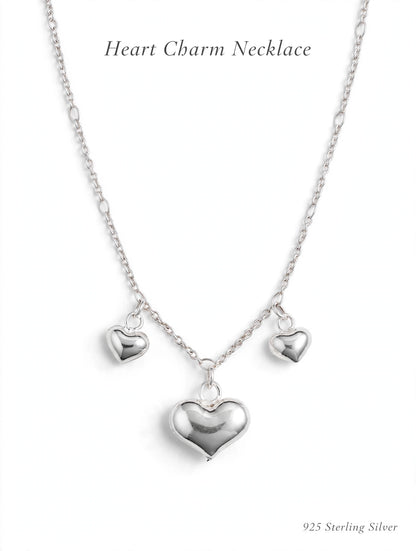 925 sterling silver heart charm necklace with three puffy heart pendants on white background