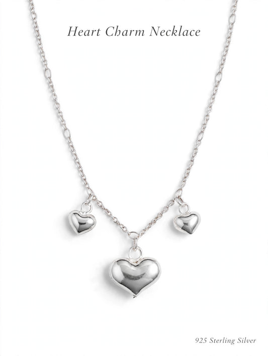 925 sterling silver heart charm necklace with three puffy heart pendants on white background